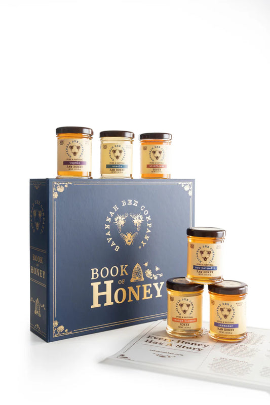 Savannah Bee Company Book of Honey sampler with six 3oz jars; three jars on the gift box and three stacked in a pyramid on the table